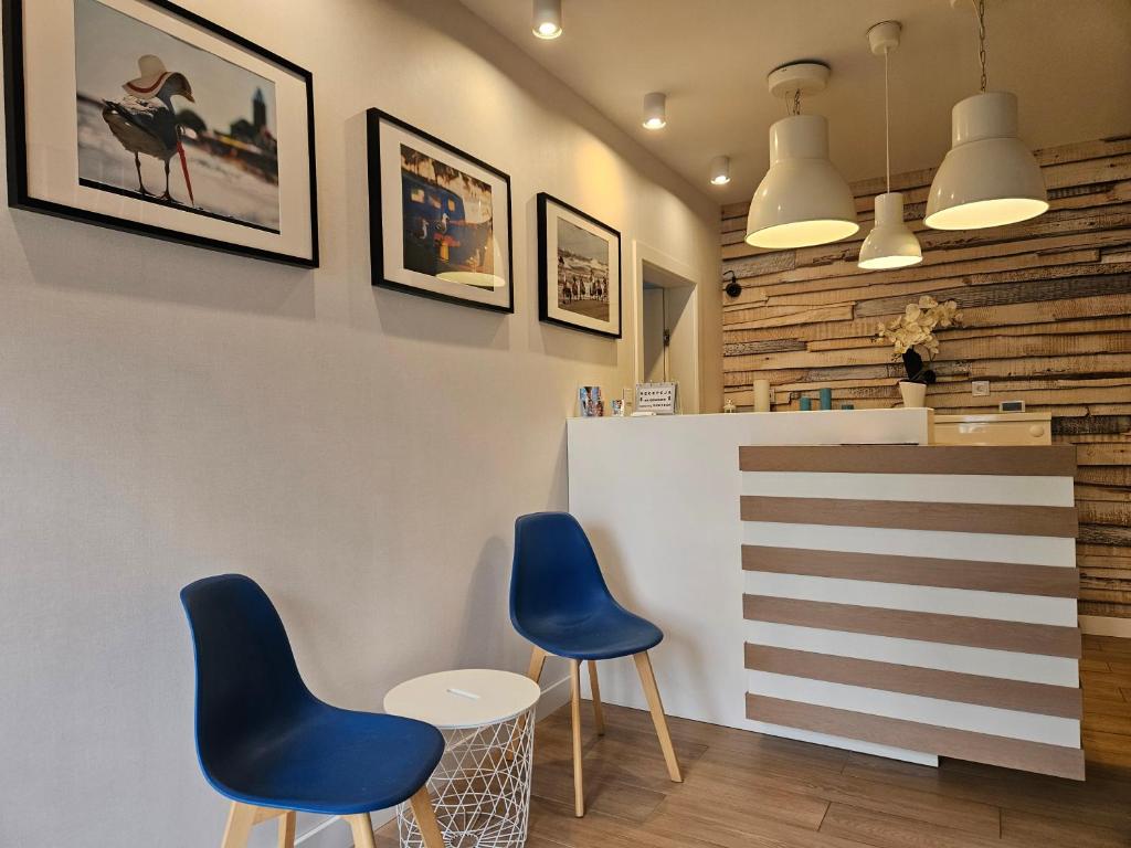 a restaurant with two blue chairs and a counter at Piotruś Pan in Niechorze