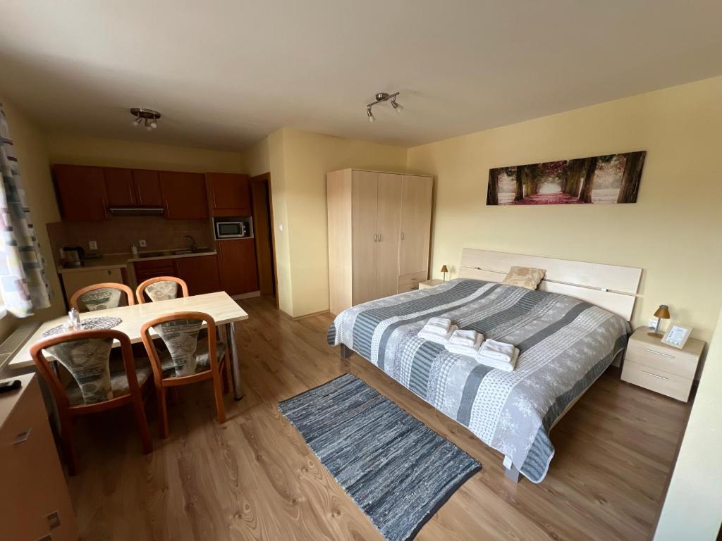 a bedroom with a bed and a table and chairs at Beška in Bešeňová