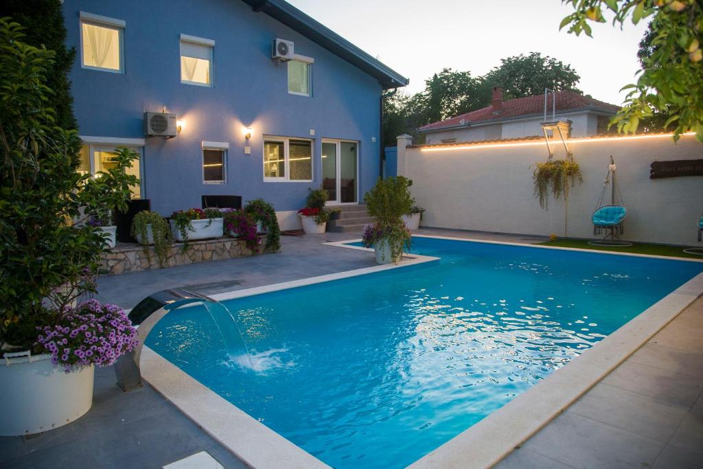 a swimming pool in front of a house at Private Riverside Villa Silvia in Mostar