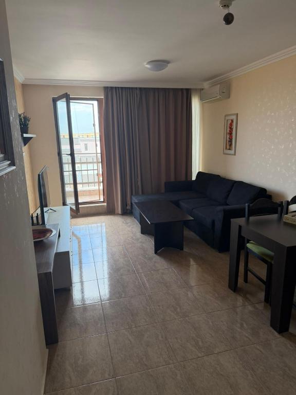 a living room with a blue couch and a table at Premium Apartments in Sveti Vlas