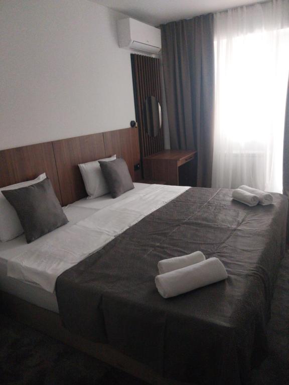a bedroom with a large bed with two towels on it at Prenoćište SRBIJA in Surdulica