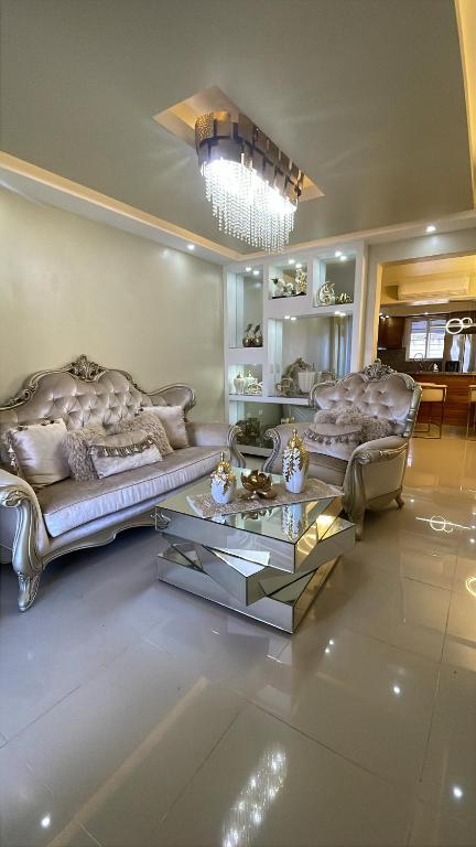 a living room with two couches and a table at Apt cómodo a 6 minuto de megacentro in El Bonito