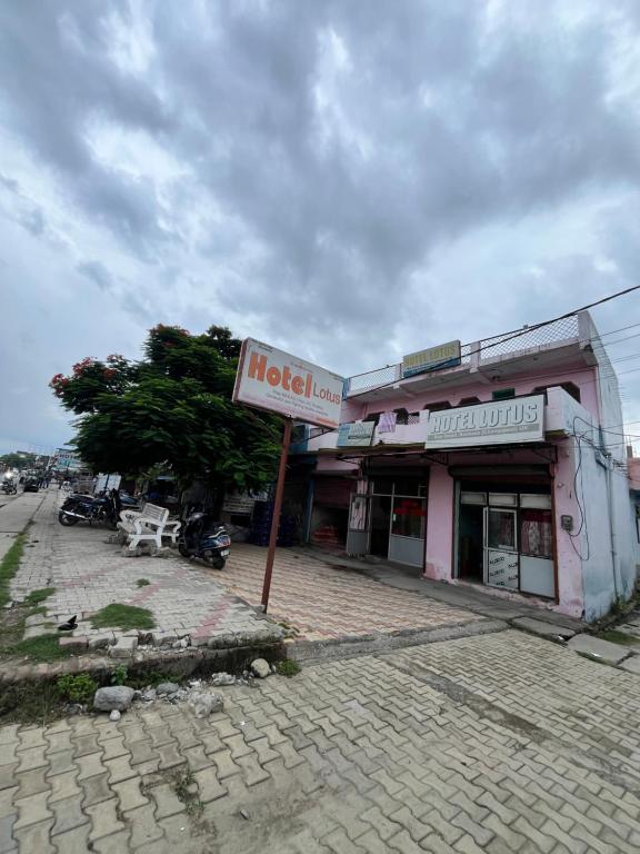 a hotel sign in front of a building at Hotel Lotus in Banbāsa