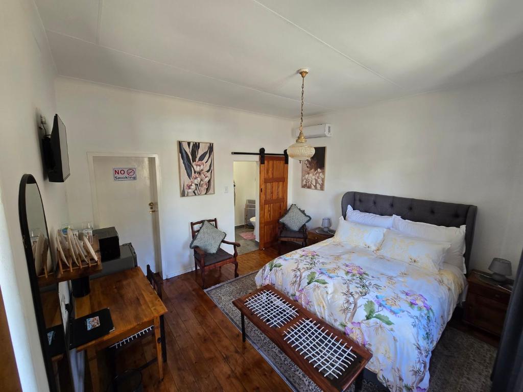 a bedroom with a bed and a wooden floor at Eagles Accommodation in Colesberg