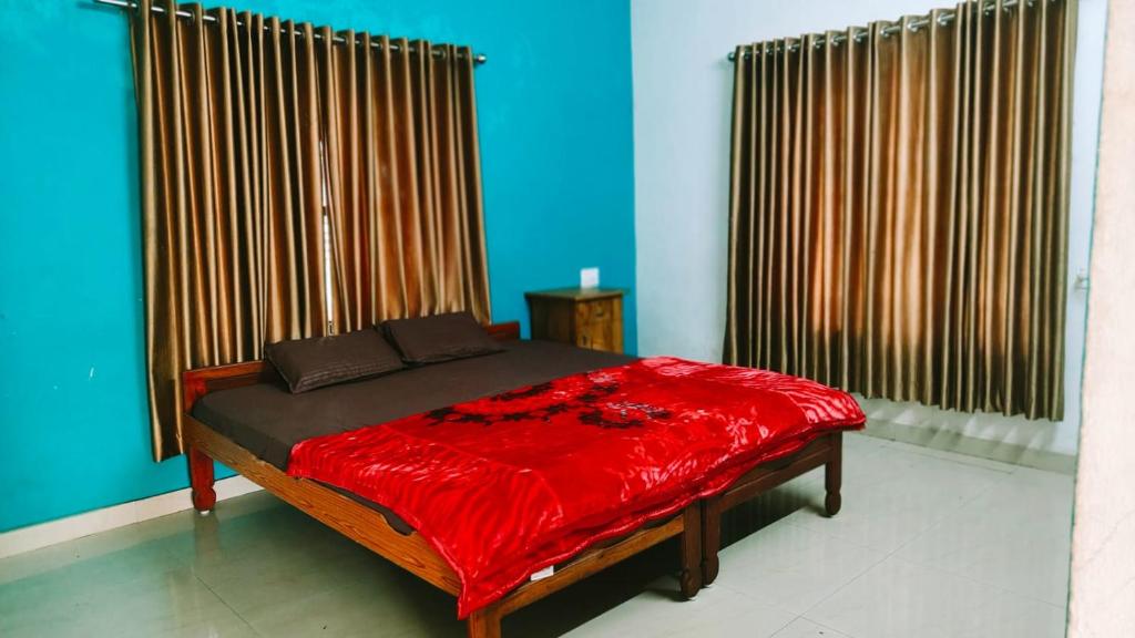 a bedroom with a bed with a red blanket at Sivadurga in Varkala