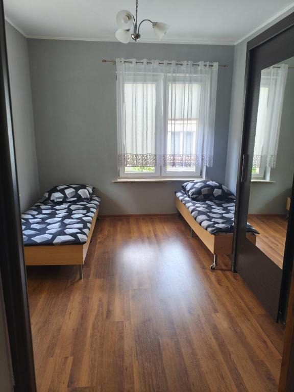 two beds in a room with two windows at Hostel Tet6 in Gdynia