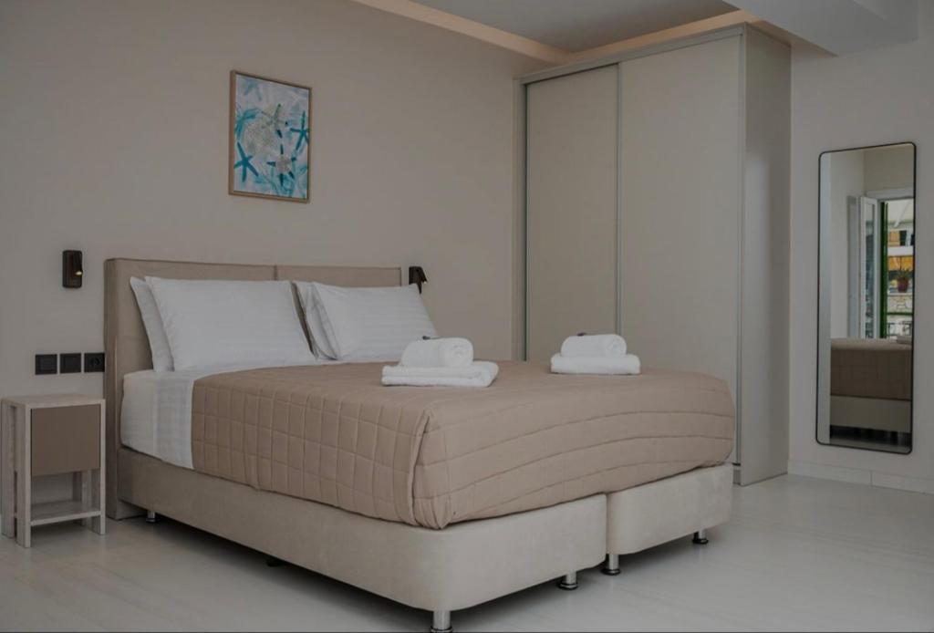 a bedroom with a bed with two towels on it at Dimitra Suites in Pythagoreio