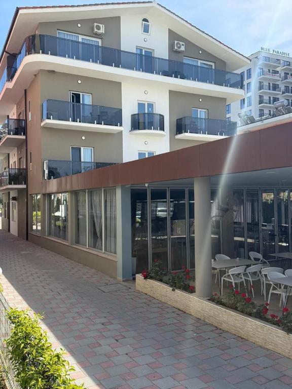 a building with tables and chairs in front of it at Hotel Leodori 1 in Shëngjin