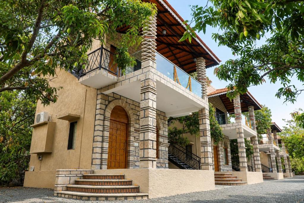 a house with stairs leading up to it at Gir Vintage Villa in Sasan Gir