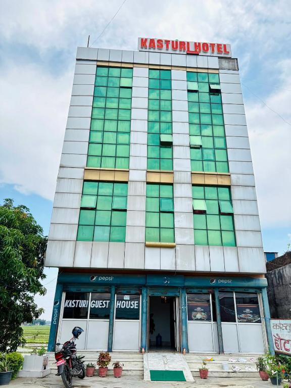 ein Gebäude, vor dem ein Motorrad geparkt ist in der Unterkunft Kasturi Hotel in Champapur
