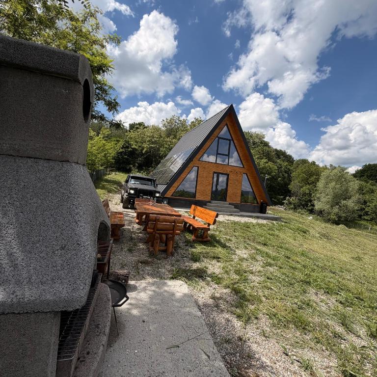a cabin with picnic tables in front of a building at Cabana Z-Haven in Ungureni
