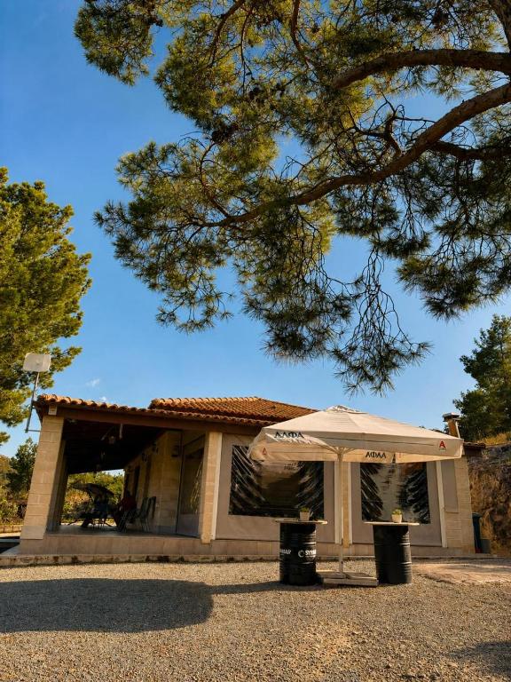 a white umbrella sitting in front of a building at Stavros Country House in Siá