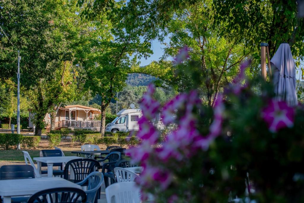 a bunch of tables and chairs with a van in the background at Camping Onlycamp du Rouergue in Villefranche-de-Rouergue