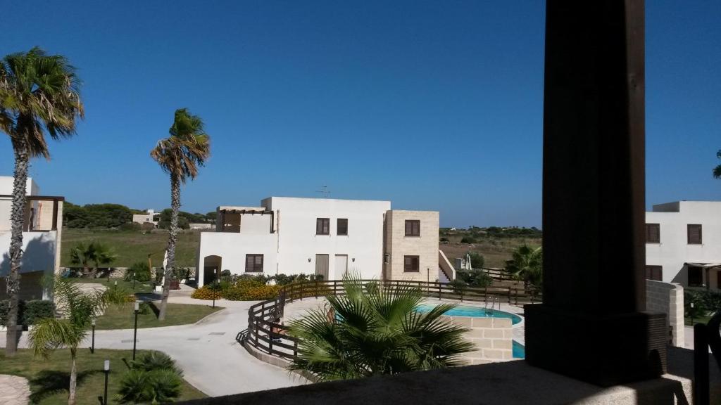 vista su un edificio con piscina e palme di Casa Vacanze Lido Burrone a Favignana