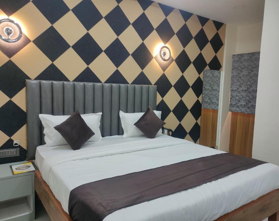a bedroom with a large white bed in a room at Hotel Abhijeet Inn in Raipur