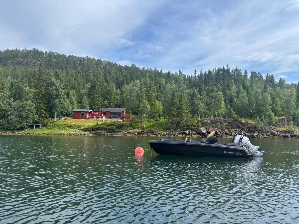 a boat on a lake with a house in the background at 9 person holiday home in Mosvik-By Traum in Mosvik
