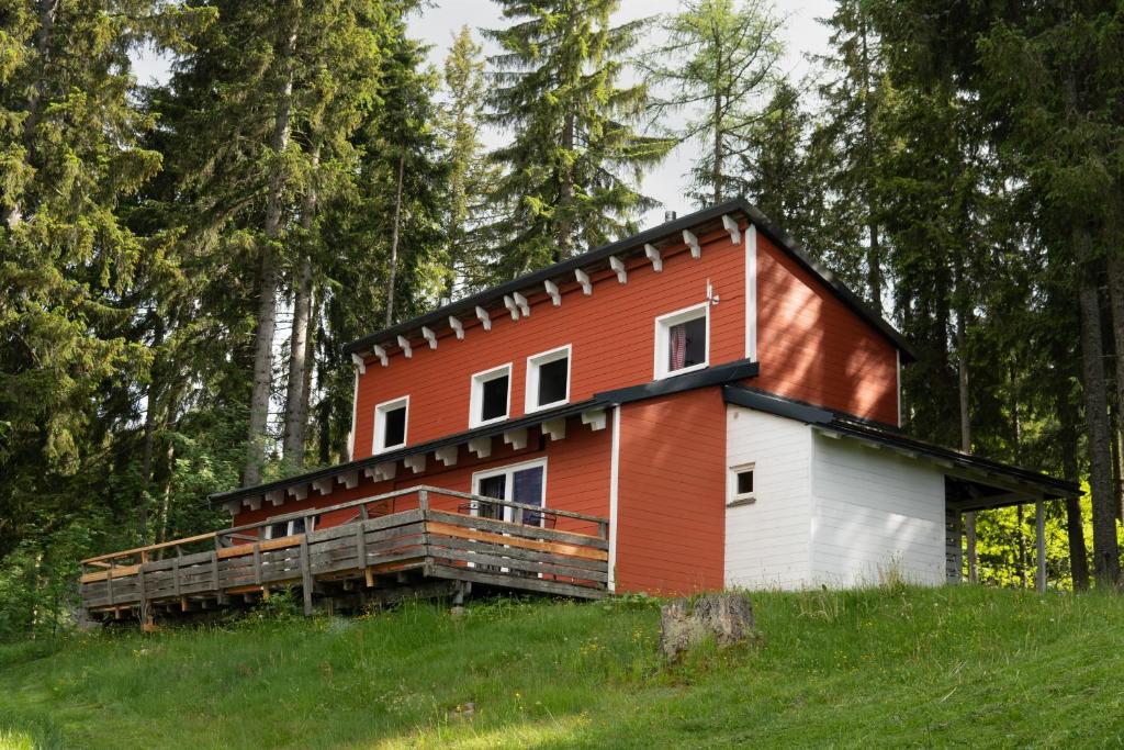 a red and white house on a hill with trees at miki Chalets in Pack