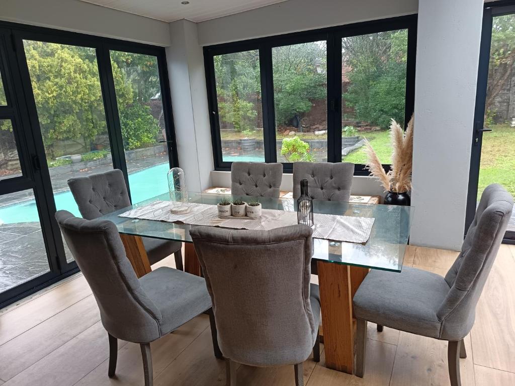 a dining room with a glass table and chairs at Almond Place in Tokai