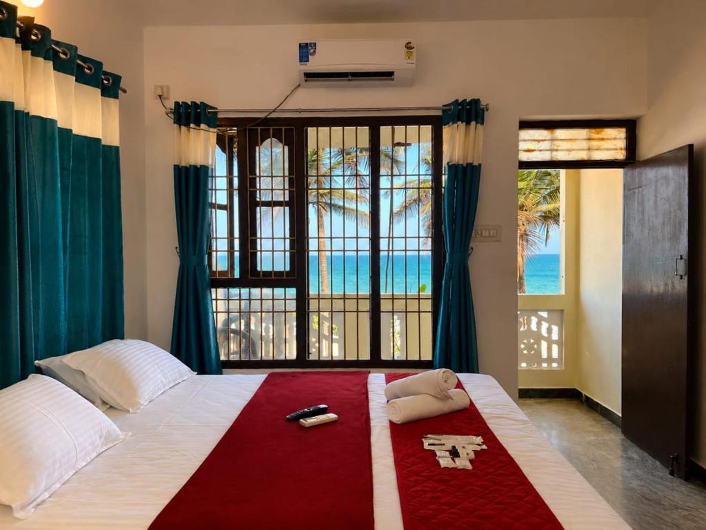 a bedroom with a bed with a view of the ocean at La Muthu Beach Stay in Pondicherry