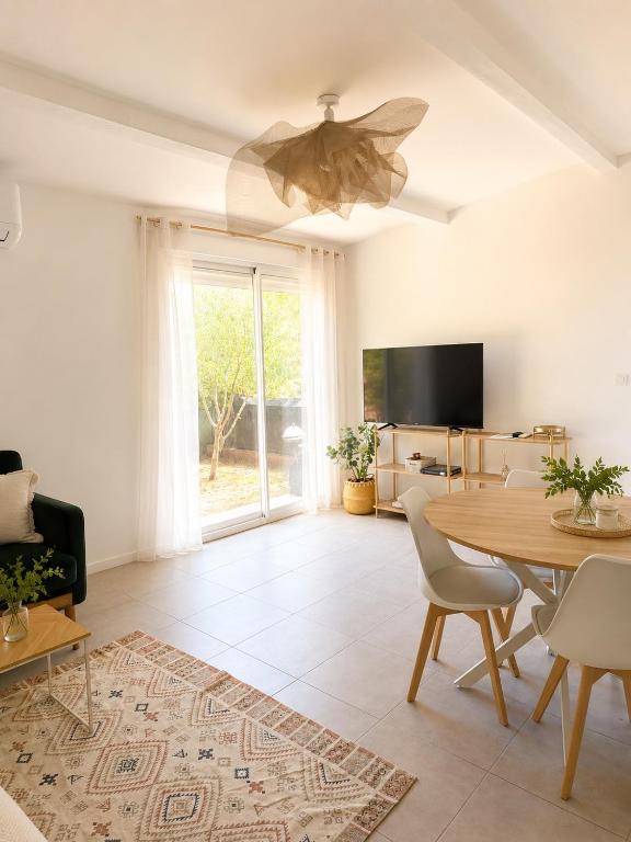 a living room with a table and a ceiling fan at La Maison du Cerisier in Manosque