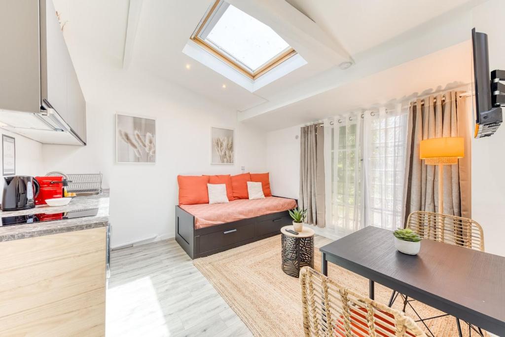 a kitchen and living room with a bed and a table at Bright studio - RER B - Plateau de Saclay in Palaiseau