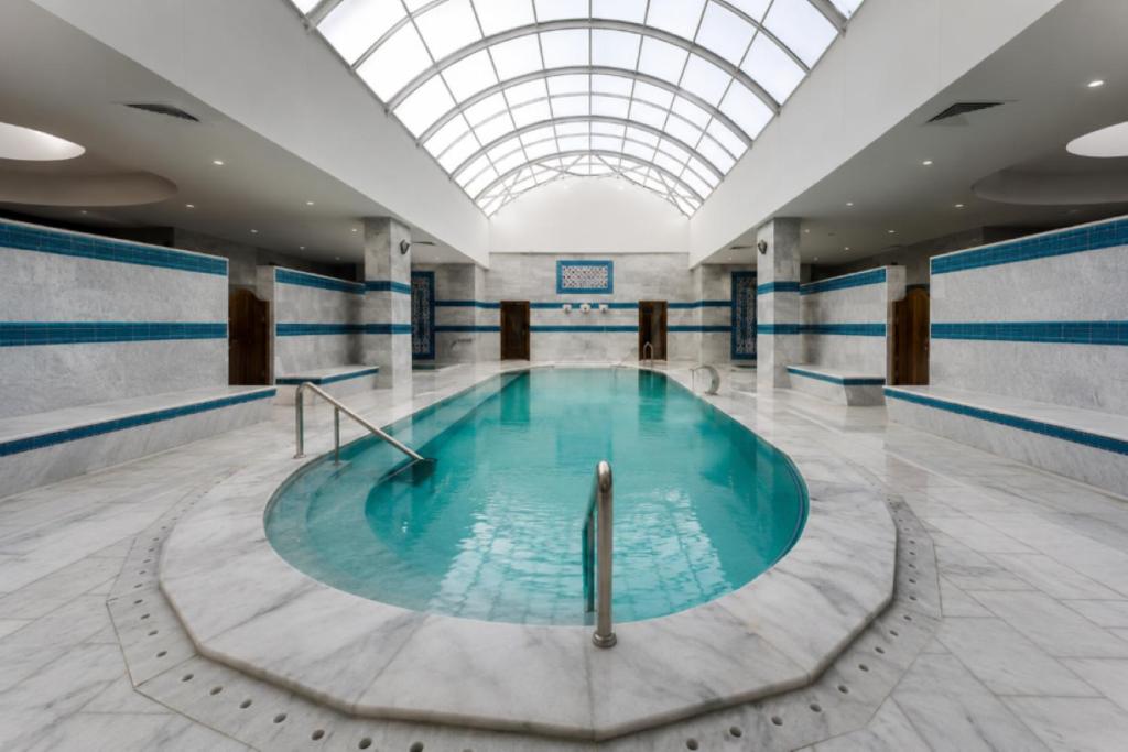 a swimming pool in a building with a glass ceiling at Safa Sorgun Thermal Hotel Wellness & SPA in Sorgun