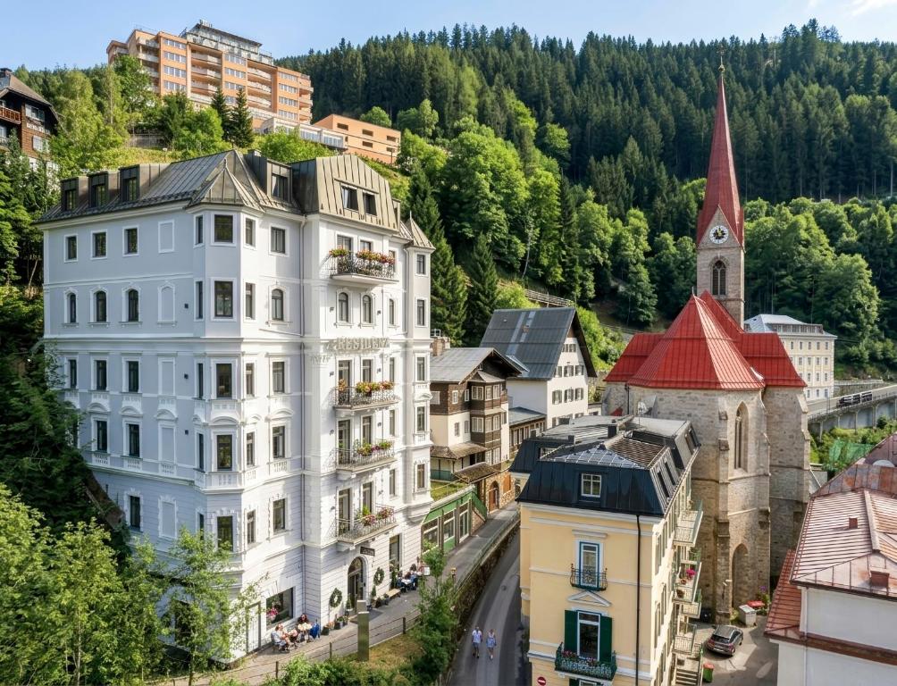 a city with a white building and a church at Residenz Boutique Suites in Bad Gastein