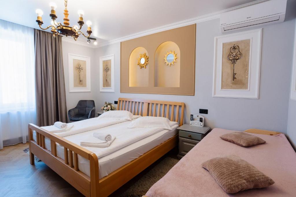 a bedroom with two beds and a chandelier at Vila Sibiu in Sibiu