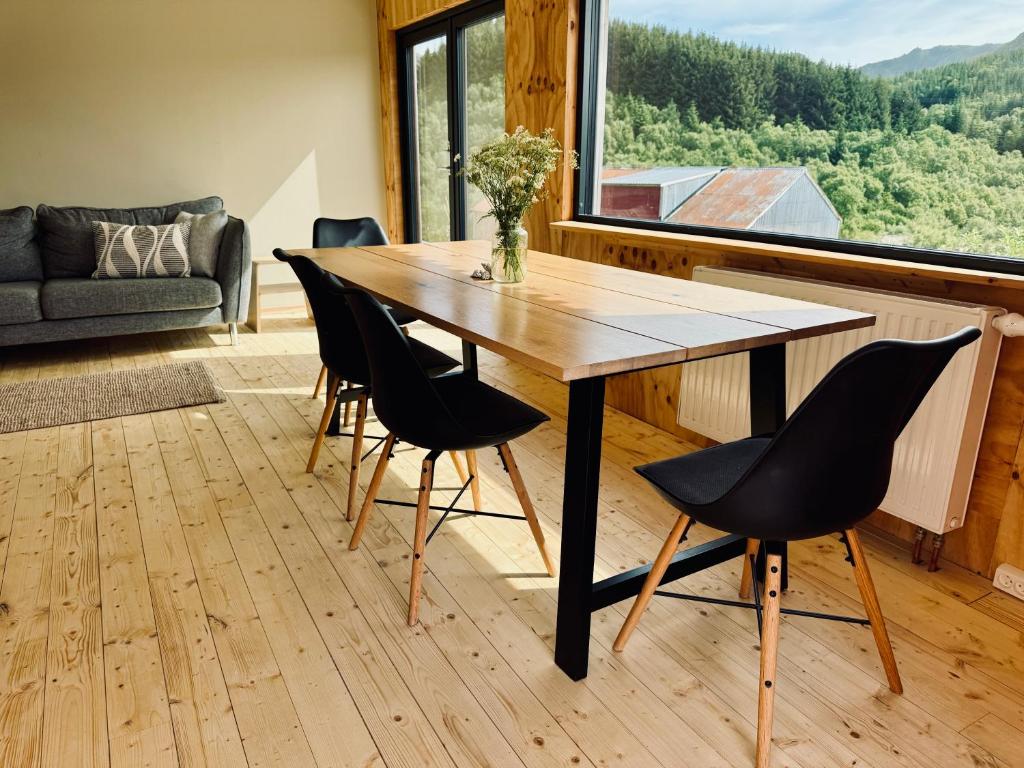a dining room with a wooden table and chairs at Nykmark Eco Residence in Unnstad