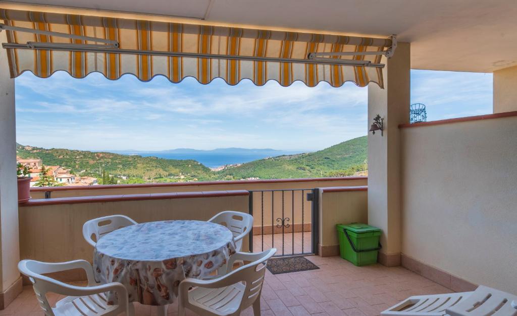 a balcony with a table and chairs and a view at Appartamento Vista Nel Mare Blu in Rio nellʼElba