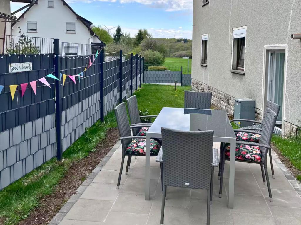 a patio with a table and chairs and a fence at Eifel Moments in Kall