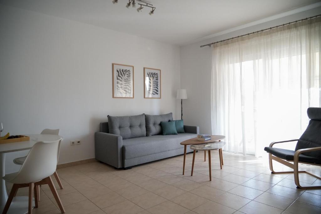 a living room with a couch and a table at Meltemi by GG in Alexandroupoli