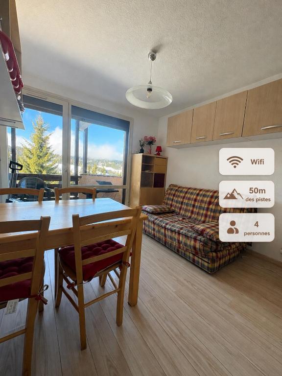 a living room with a table and a couch at Hirmentaz in Bellevaux