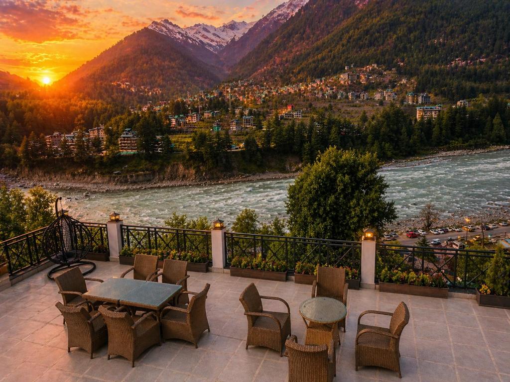 a patio with a table and chairs overlooking a river at Hotel Hollywood Manali - Scenic River & Mountain View With Premium Rooms Near Mall Road in Manāli