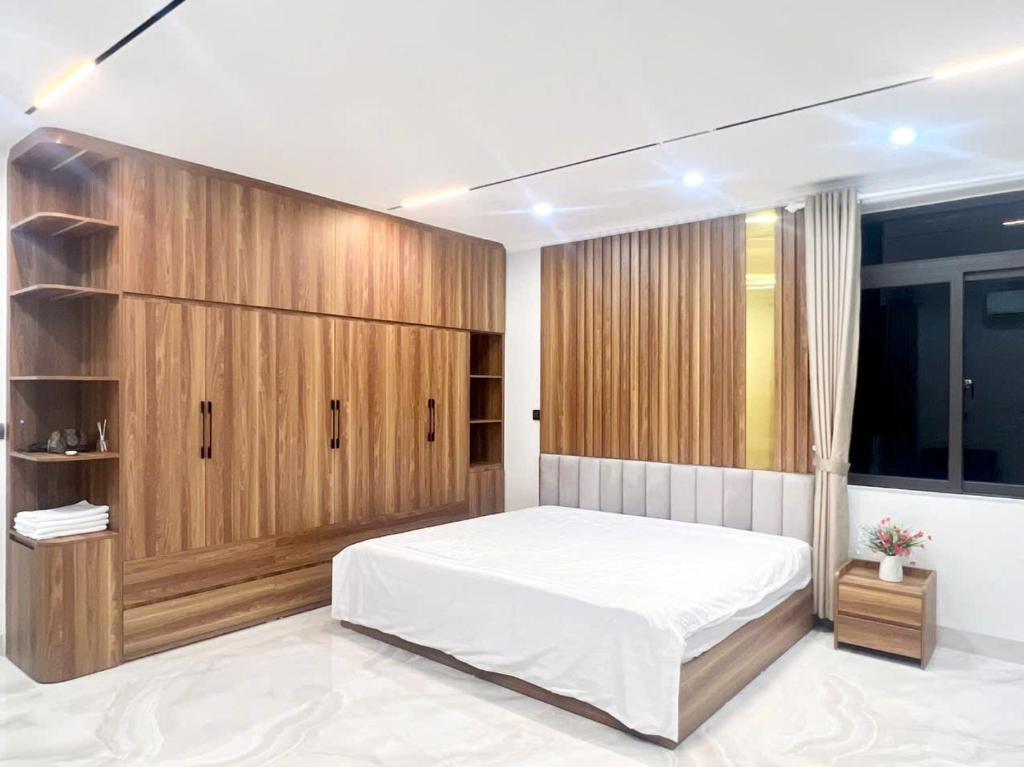 a bedroom with a large bed and wooden cabinets at Phố Cổ Villa Ninh Bình in Kỳ Vĩ
