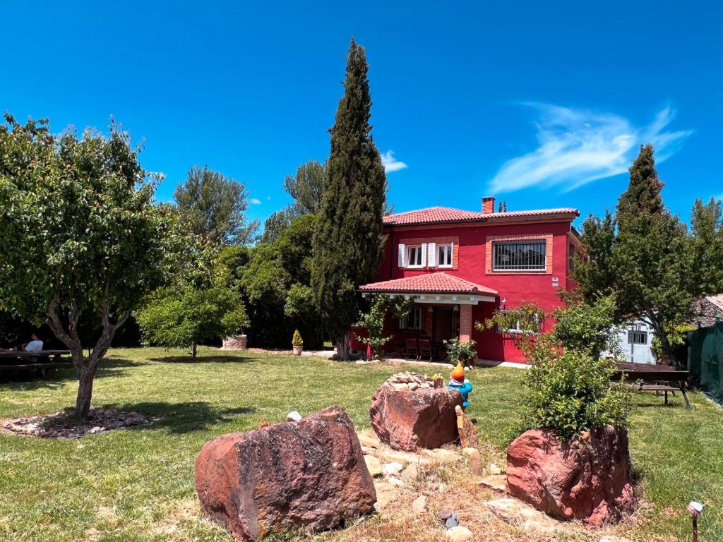a red house with two large rocks in the yard at Casa Roja Sigüenza in Sigüenza