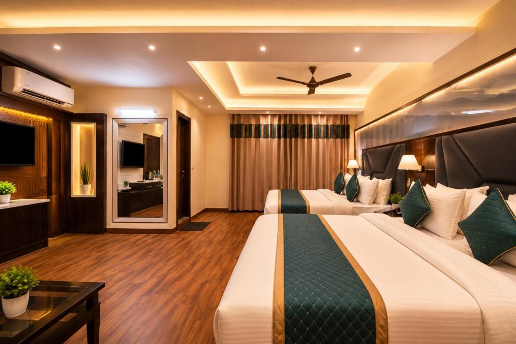 a hotel room with two beds and a ceiling fan at Hotel Geet Deluxe Near Connaught Place and New Delhi Railway Station in New Delhi