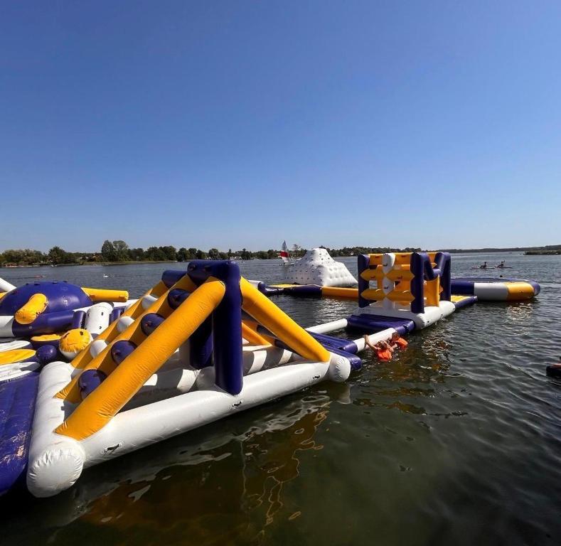 a row of inflatable water slides in the water at Panorama Resort in Klusek Biały