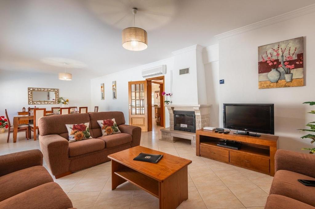 a living room with a couch and a tv at Villa Fatima by Villa Select in Galé