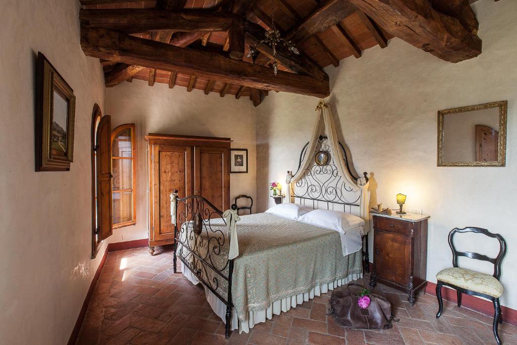 a bedroom with a bed and a chair at Villa Il Paradisino in Sesto Fiorentino