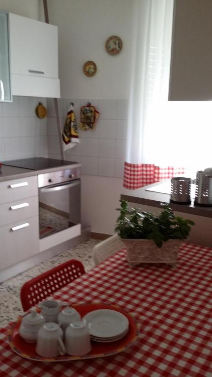 オルヴィエートにあるAppartamento Piazza Buziのキッチン(テーブル、赤と白のテーブルクロス付)