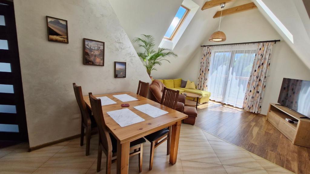 a dining room and living room with a wooden table at To Tu in Czarna Góra