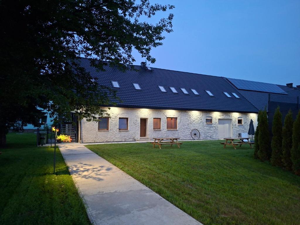 a building with two picnic tables in the grass at WINNICA 61 - Pokoje in Krotoszyce