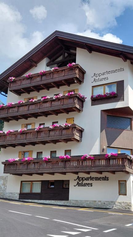 a building with balconies and flowers on the side of it at Apartments Antares in Colfosco