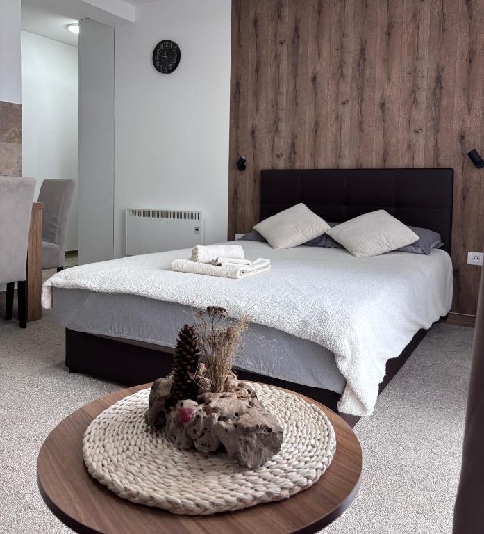 a bedroom with a large bed and a table with a table sidx sidx at Monte LUX 10 in Kopaonik