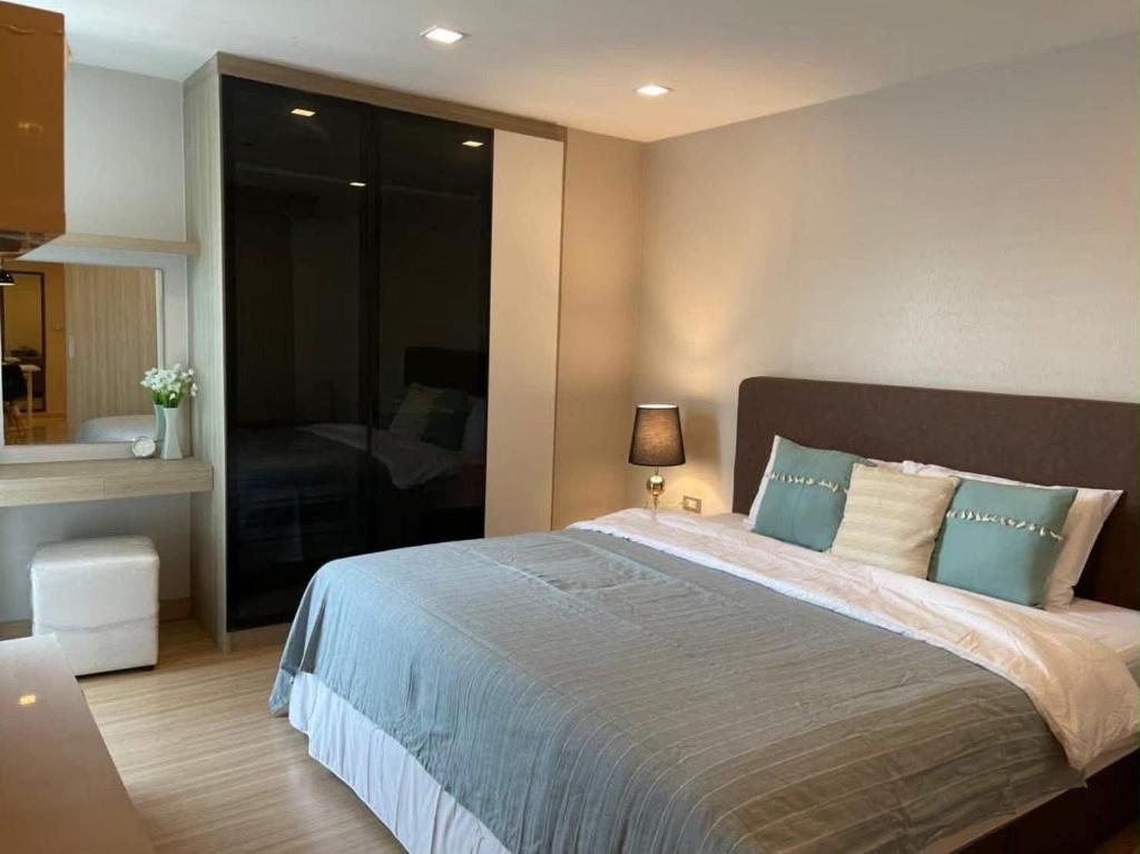 a bedroom with a large bed with blue pillows at CONDO UNIT With BALCONY in Bangkok