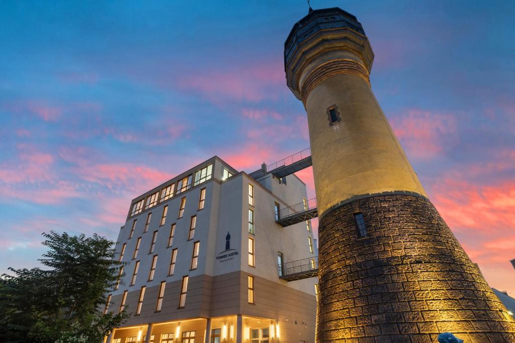 a building with a lighthouse next to a building at Tower Hotel Frankfurt in Frankfurt