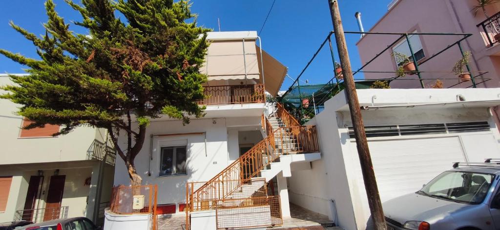 a white house with stairs and a tree in front of it at Mama's Home in Chios