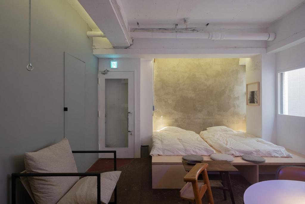 a bedroom with a bed and a table and a chair at apartment hotel Tasu Toco room 2 in Kichijōji