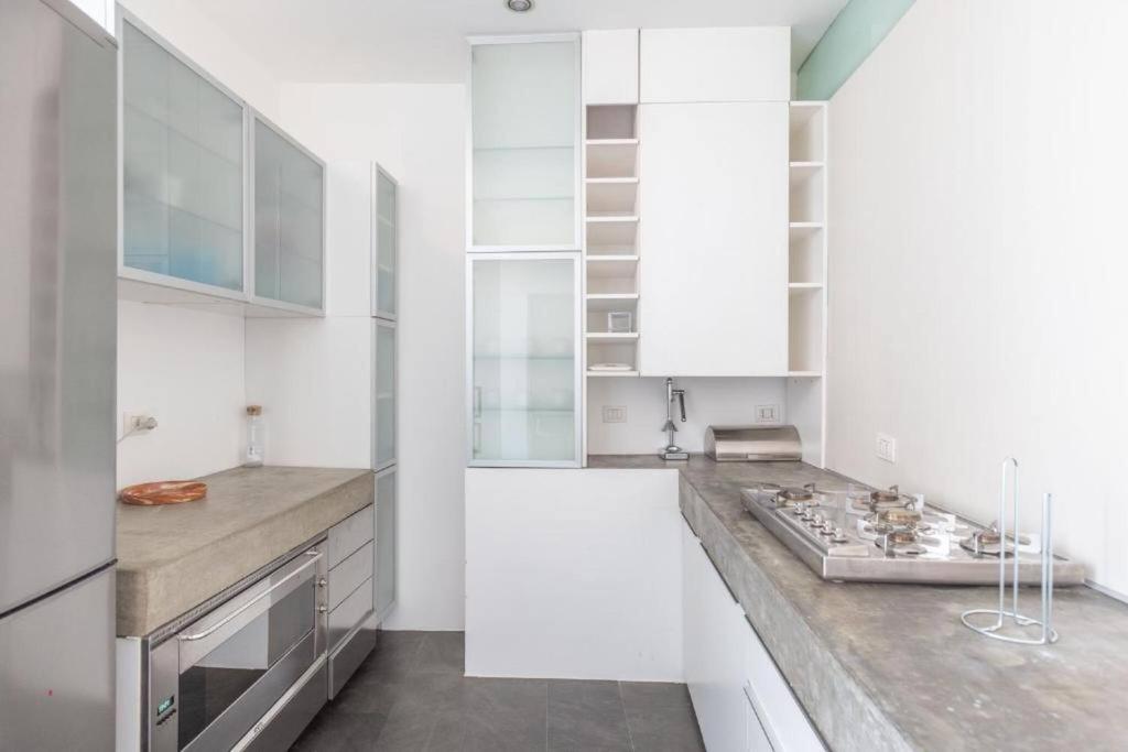 a kitchen with white cabinets and a counter at Nel Ghetto, Bologna by Short Holidays in Bologna
